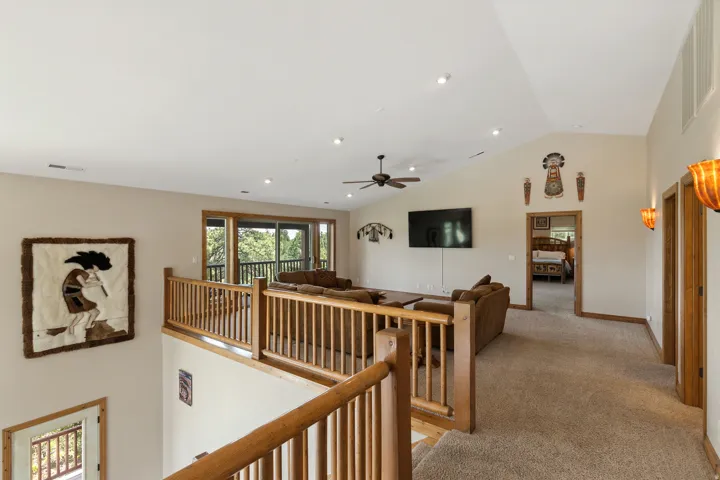Hall with vaulted ceiling, carpet flooring, and recessed lighting