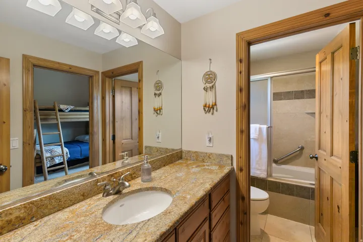 Ensuite bathroom with vanity, tiled shower / bath, and light tile patterned flooring