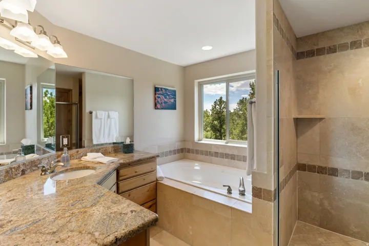Full bathroom featuring a garden tub, a stall shower, and vanity
