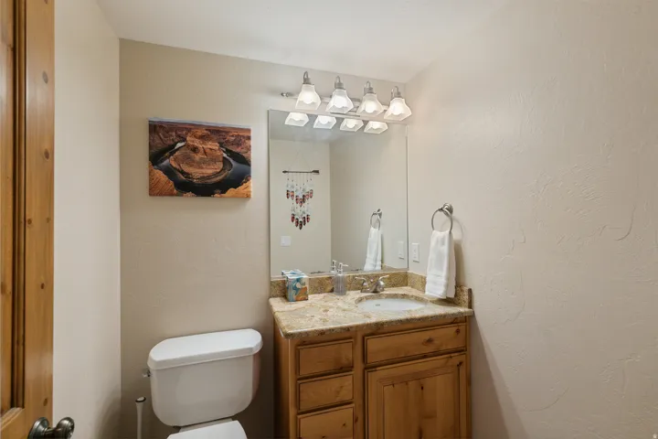 Half bath featuring a textured wall and vanity