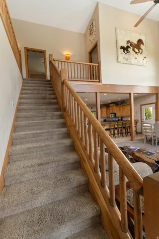 Staircase with carpet floors and a ceiling fan