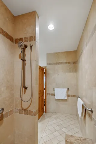 Full bath featuring a tile shower, tile walls, recessed lighting, and tile patterned flooring