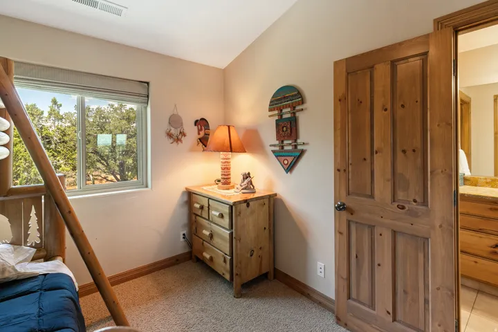 Bedroom with lofted ceiling and light colored carpet
