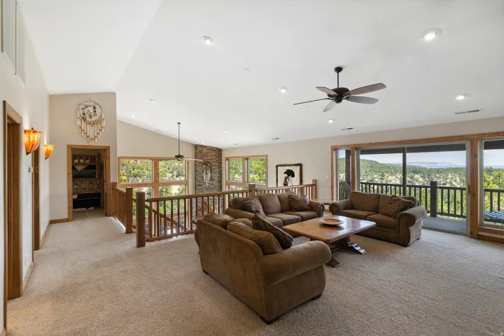 Living area with ceiling fan, light colored carpet, recessed lighting, lofted ceiling, and a mountain view