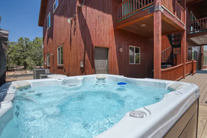 View of swimming pool featuring a hot tub and a deck