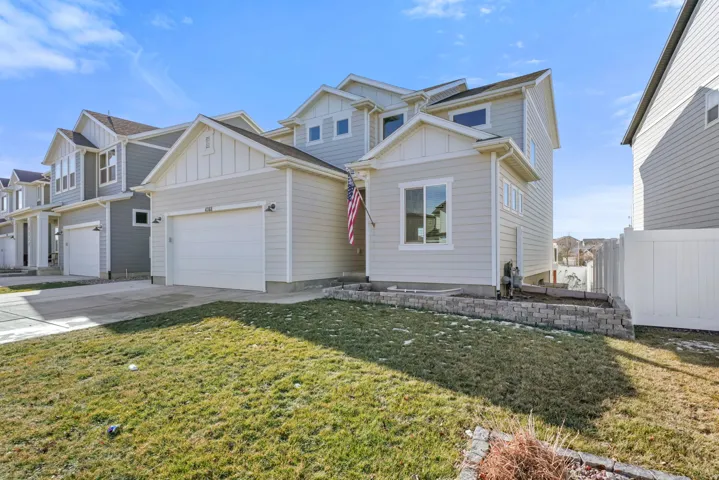 View of front of house with board and batten siding, concrete driveway, and a garage