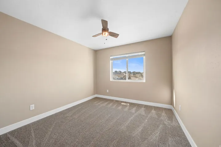 Unfurnished room featuring carpet flooring and ceiling fan