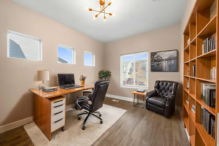 ** virtual staging ** Office area with dark wood-style floors and a chandelier