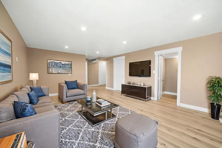 Living room with light wood finished floors and recessed lighting
