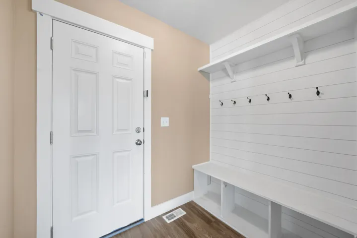 Mudroom with storage and coat hooks with door to the garage