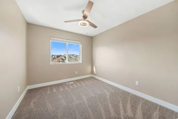 secondary bedroom with carpet and a ceiling fan
