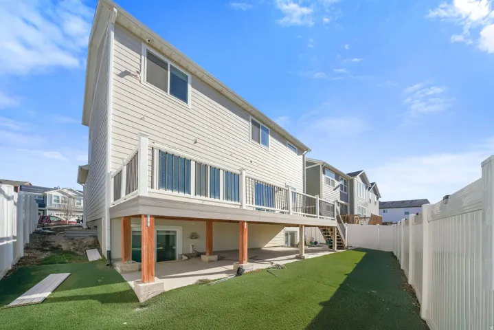 Back of house with a patio area, a wooden deck, a fenced backyard, and a residential view