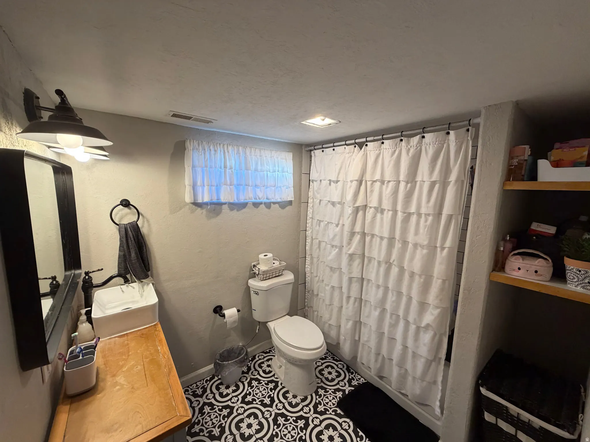 Full bathroom with curtained shower, a textured wall, vanity, a textured ceiling, and tile patterned floors