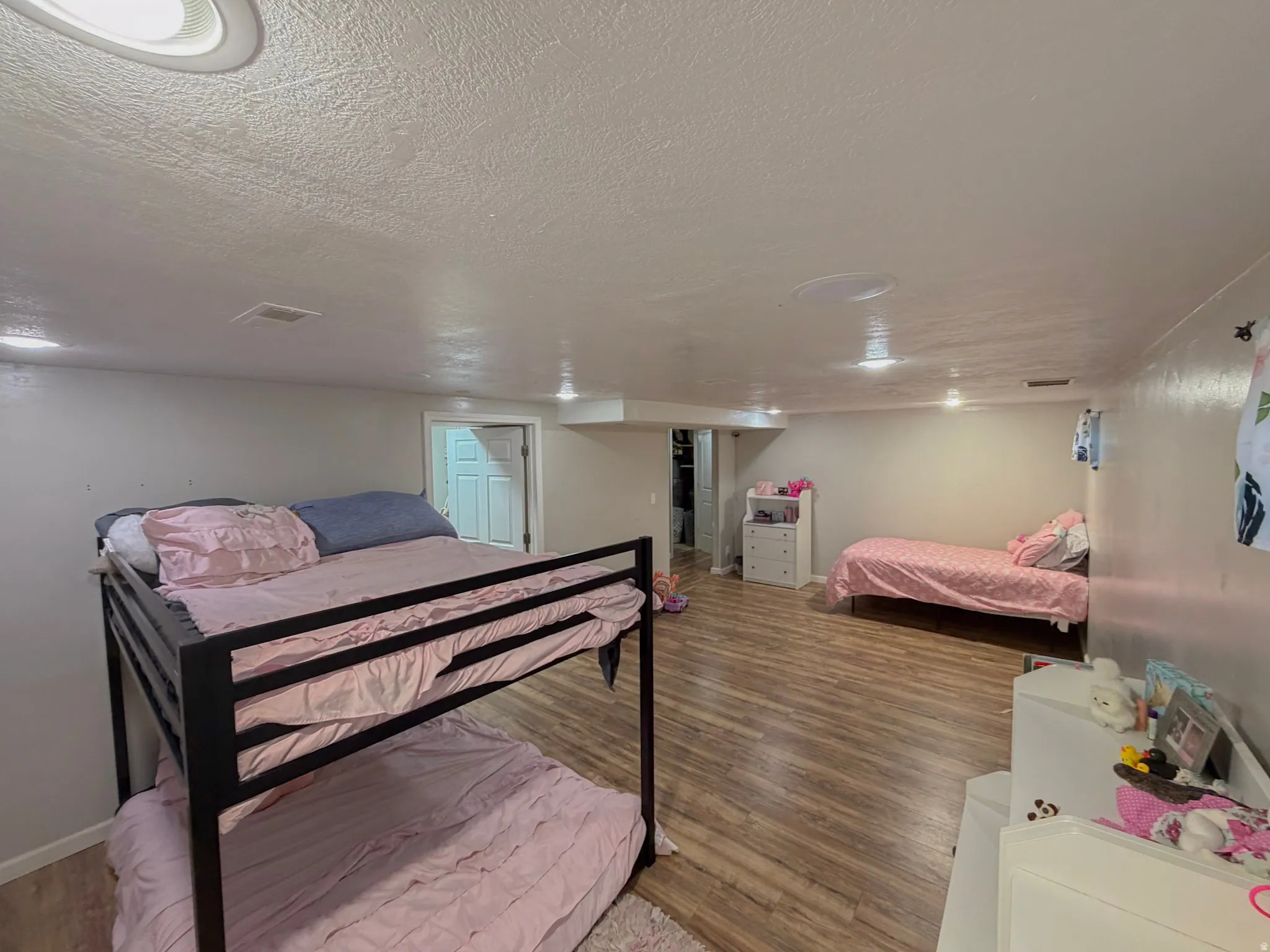 Bedroom featuring wood finished floors and a textured ceiling
