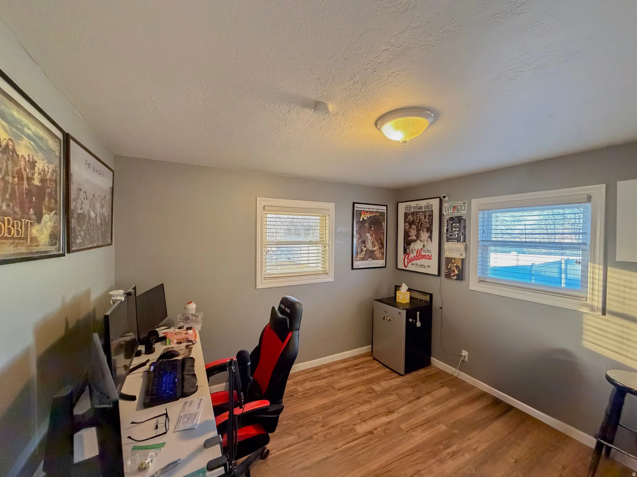 Office area with light wood-style flooring and a textured ceiling