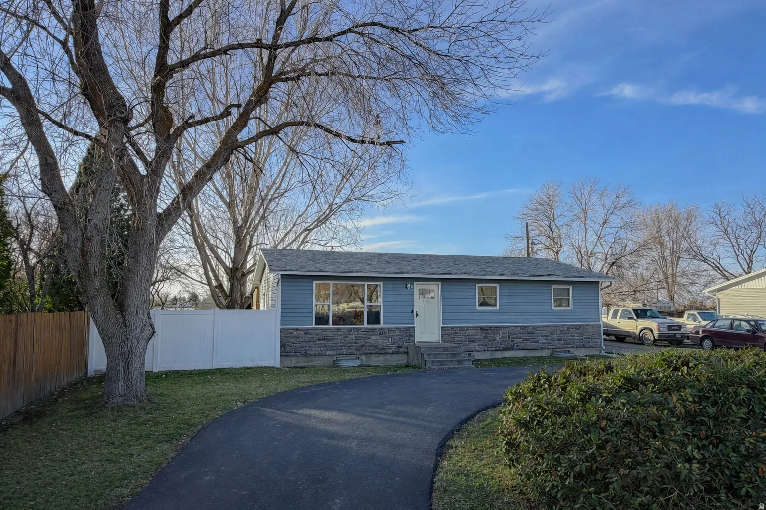 View of front of house with stone siding, a shingled roof, and entry steps