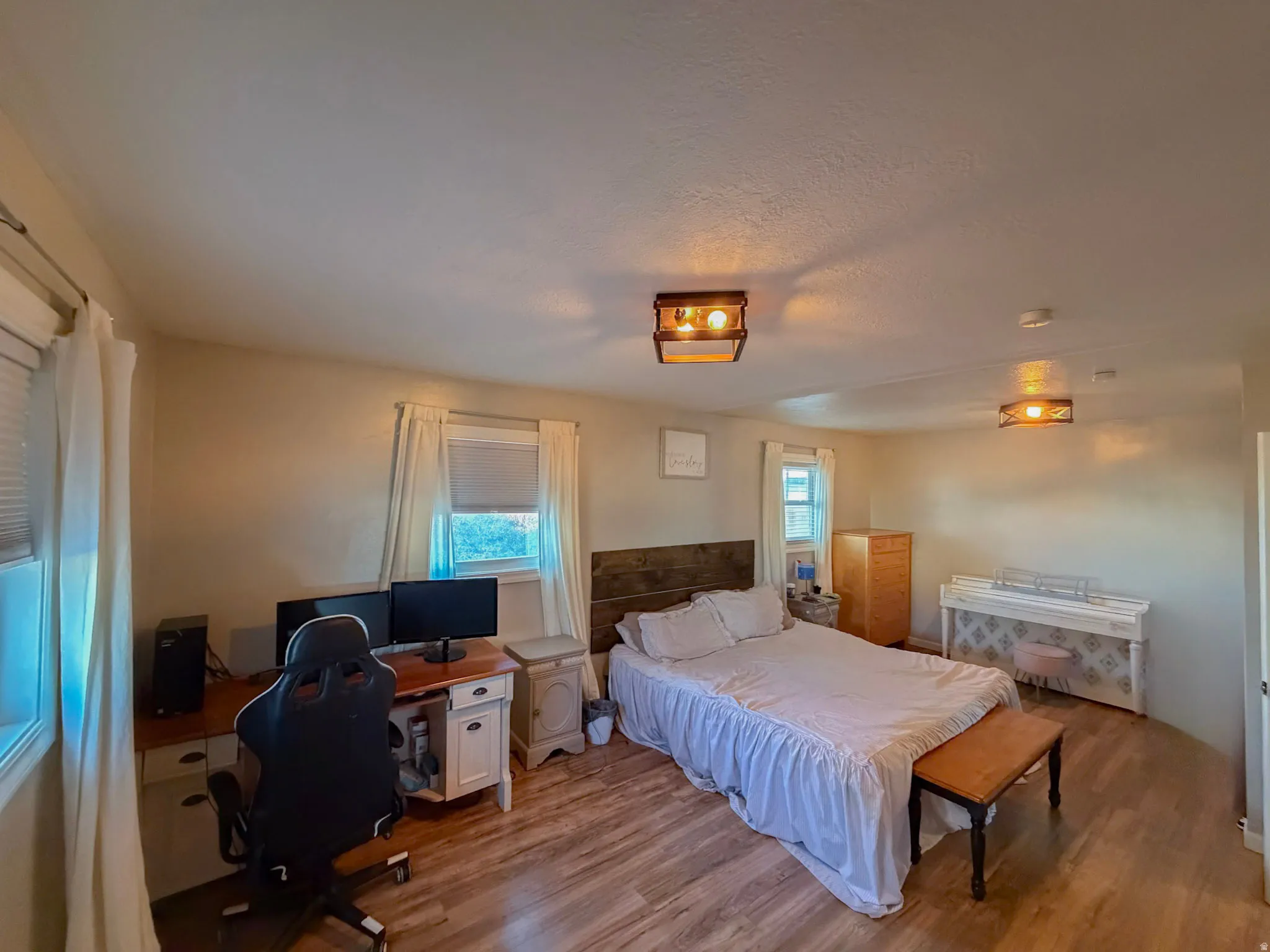 Bedroom with an office area and wood finished floors