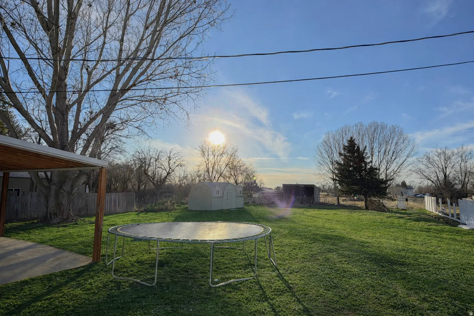 Fenced backyard with a storage shed and a trampoline