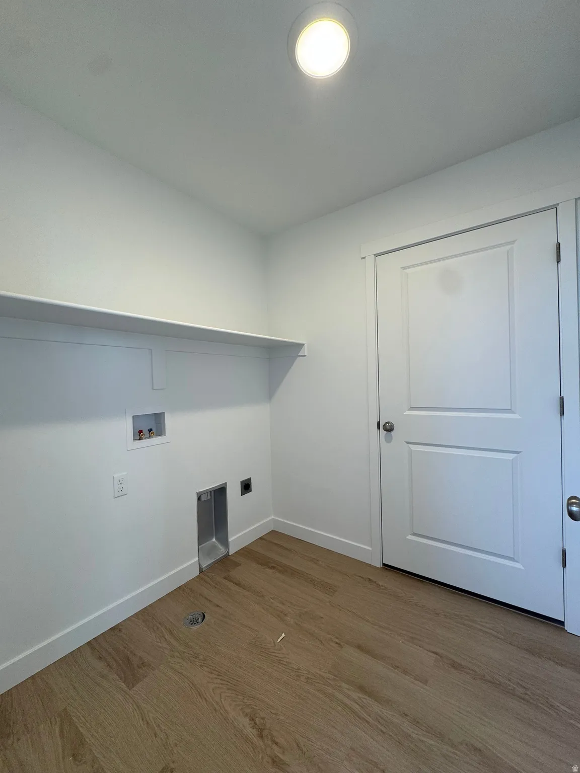 Laundry area with dark wood-style floors, washer hookup, and hookup for an electric dryer