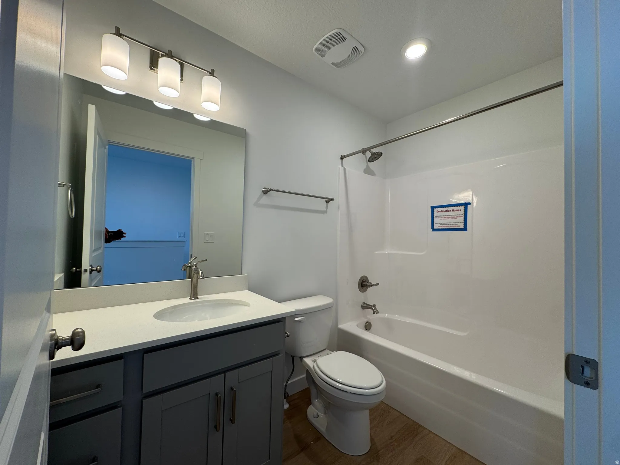 Full bath with vanity, dark wood-style flooring, and  shower combination