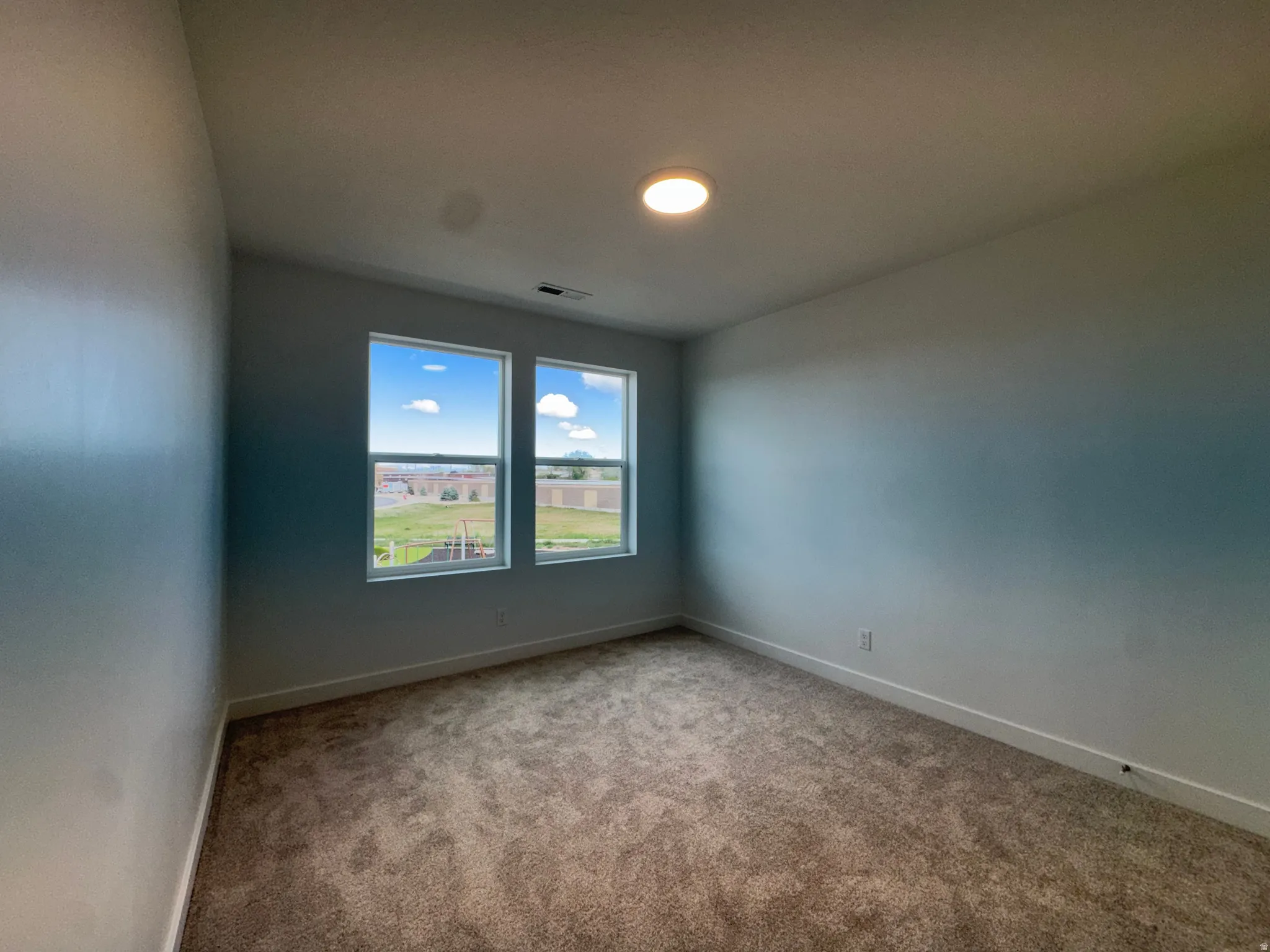 Carpeted spare room with baseboards