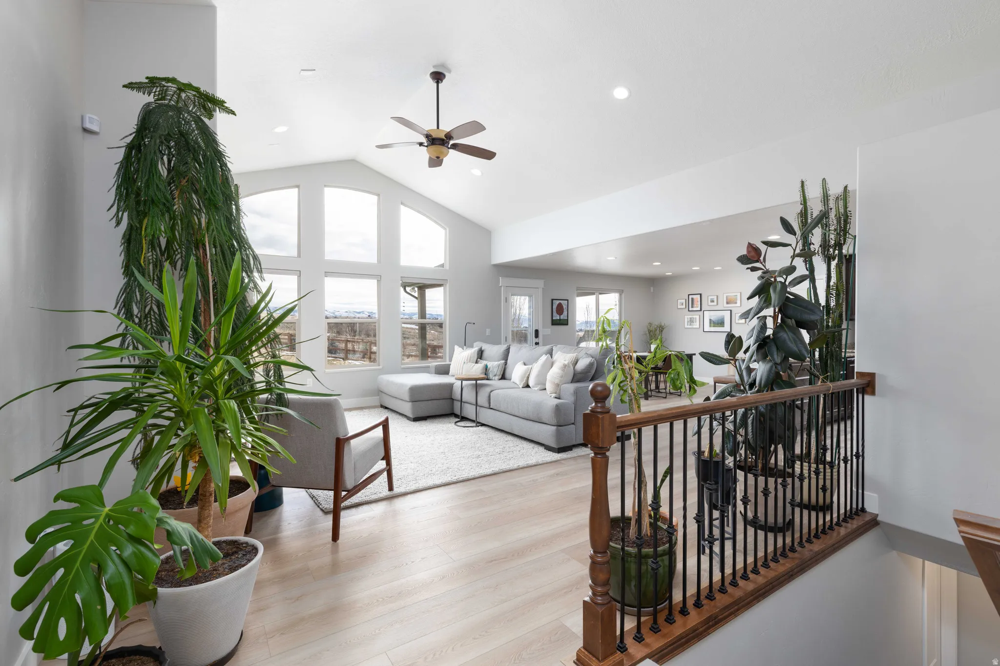 Living room with wood finished floors, lofted ceiling, a ceiling fan, and recessed lighting