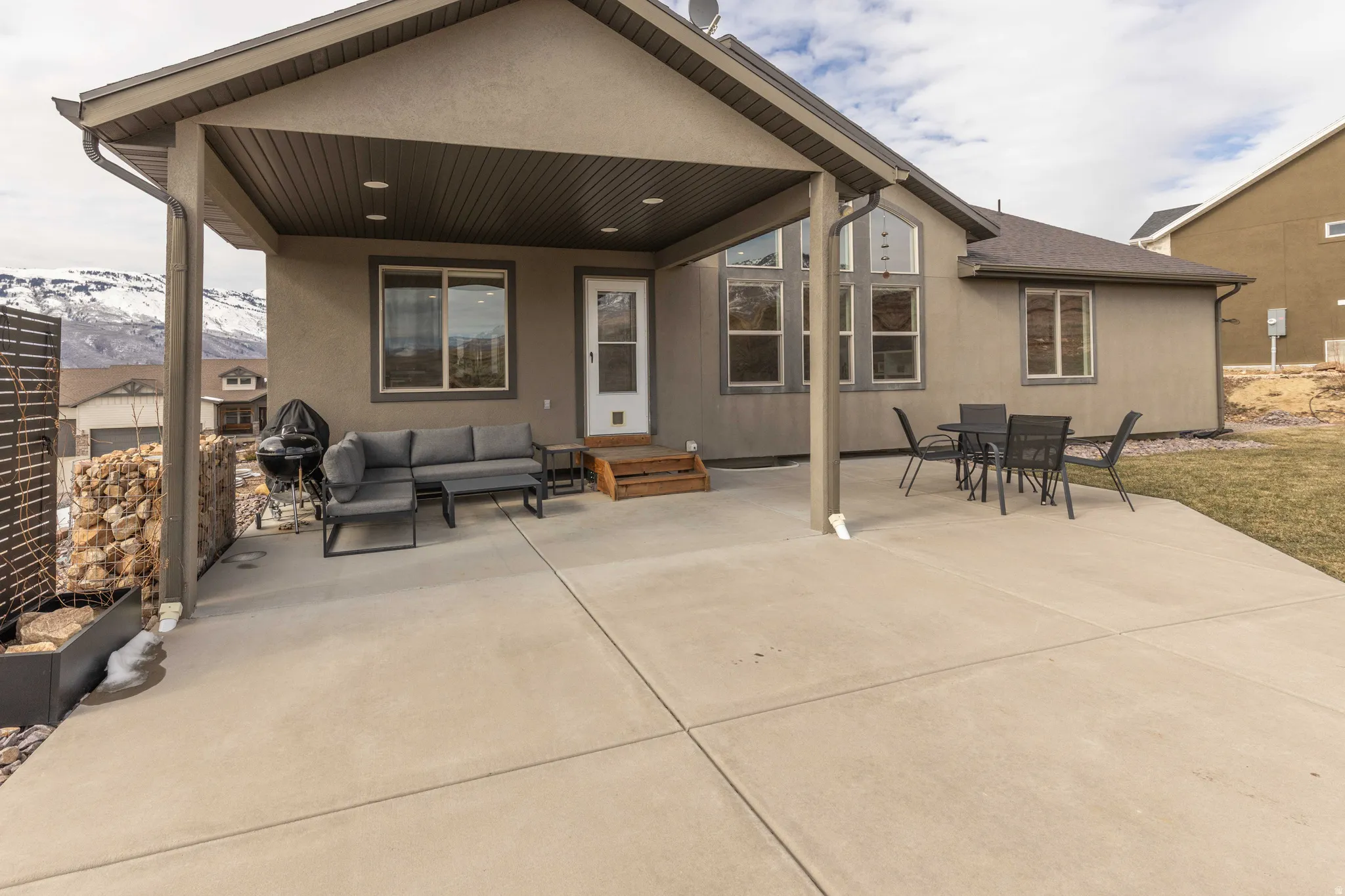 Back of house with a patio area, outdoor lounge area, and stucco siding