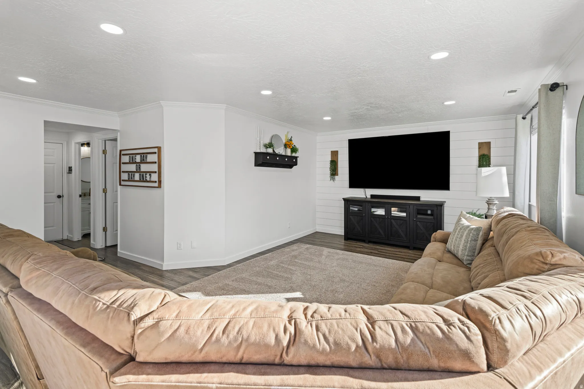 Living area featuring wood finished floors, crown molding, recessed lighting, and a textured ceiling