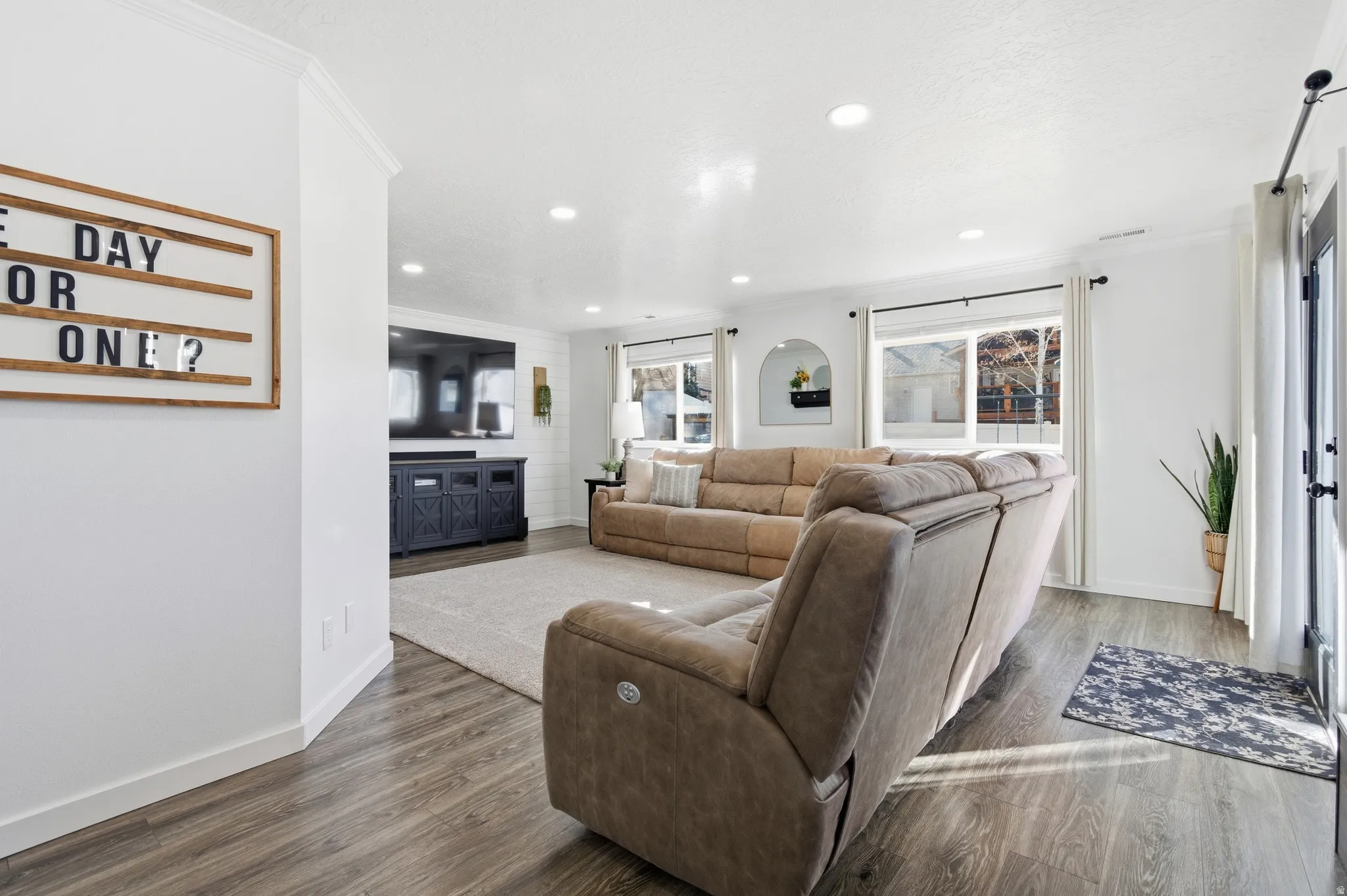 Living room featuring wood finished floors, crown molding, and recessed lighting