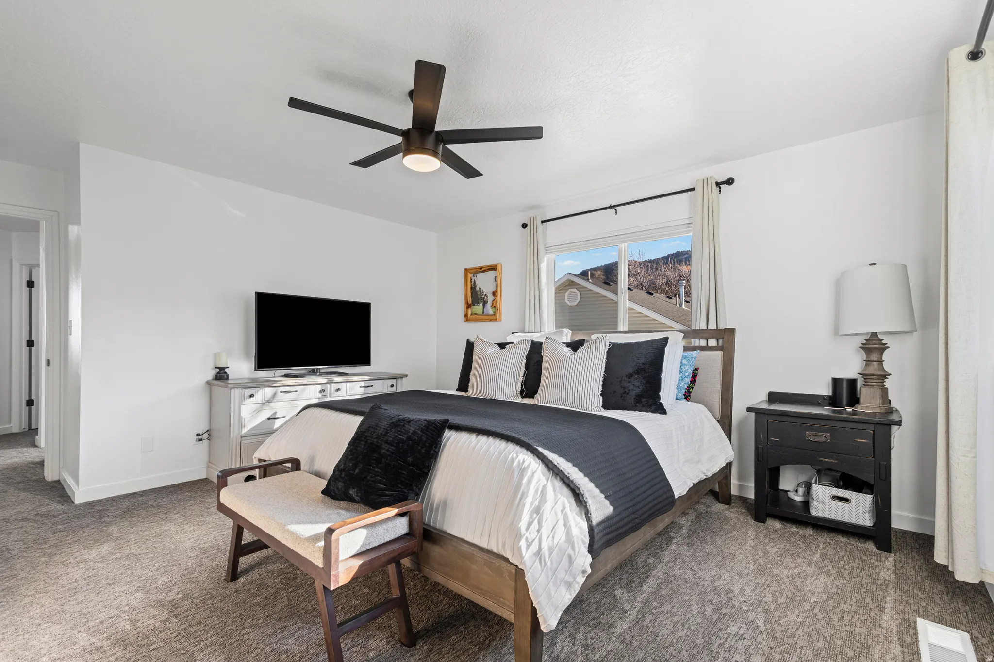 Carpeted bedroom featuring a ceiling fan and baseboards