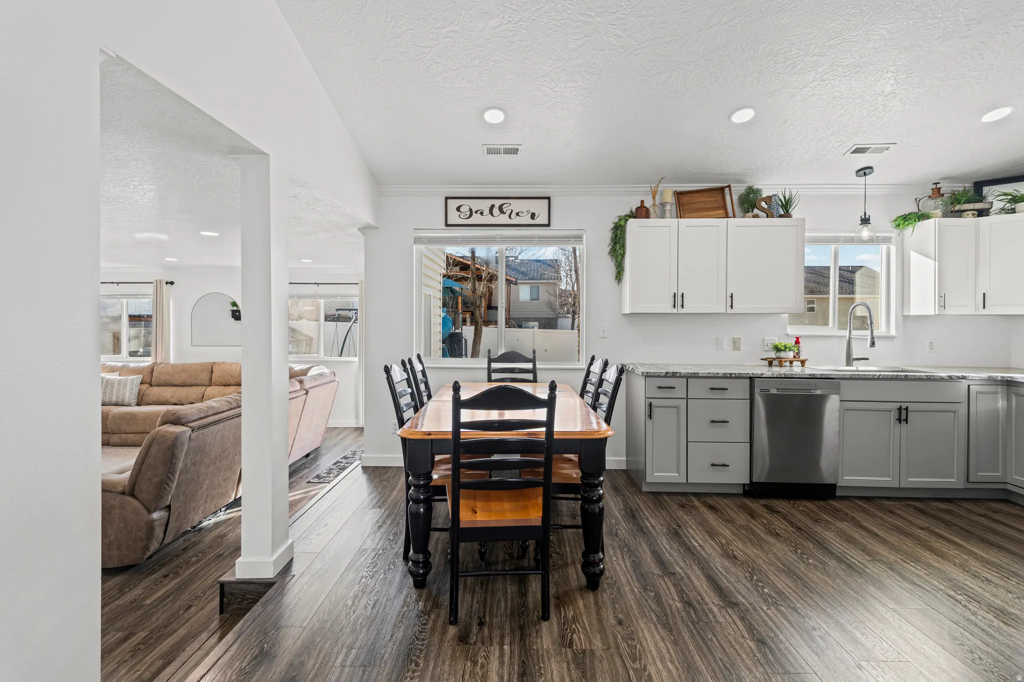 Dining area featuring a textured ceiling, dark wood-style flooring, and recessed lighting