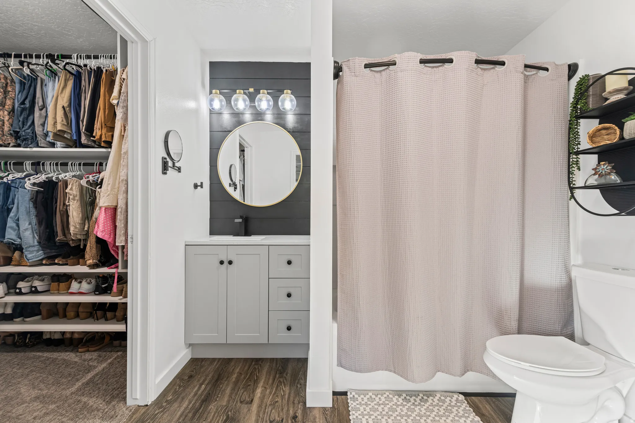 Bathroom with vanity, shower / tub combo, dark wood-type flooring, a textured ceiling, and a spacious closet