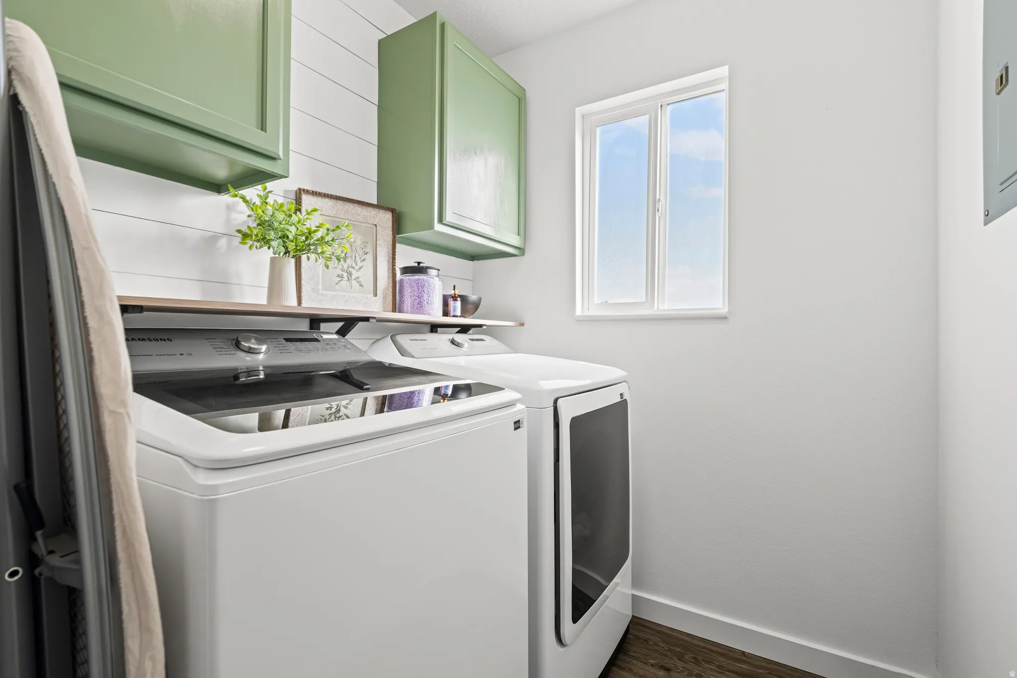 Laundry area with cabinet space, washer and dryer, and dark wood-type flooring