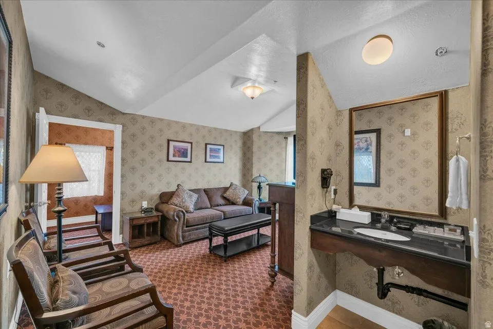 Living room featuring dark carpet and wallpapered walls