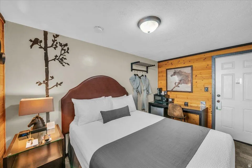 Bedroom featuring wooden walls and a textured ceiling