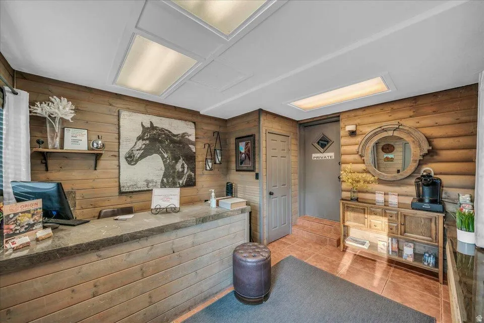 Bar with tile patterned floors, wooden walls, and log walls