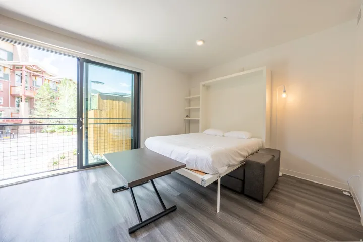 Bedroom with dark wood-style floors, access to exterior, and recessed lighting