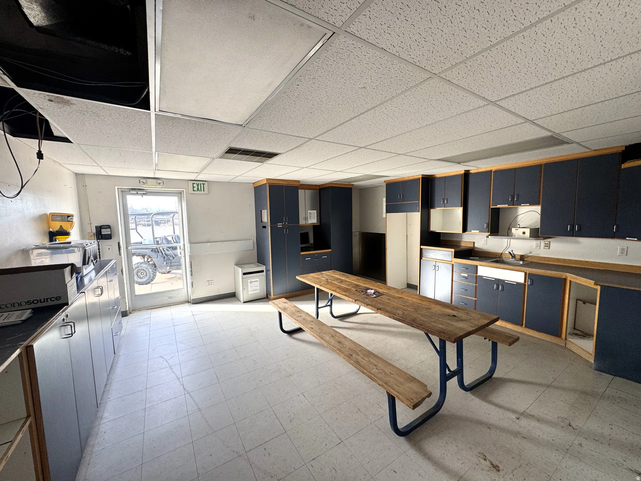 Kitchen with a paneled ceiling and dark countertops