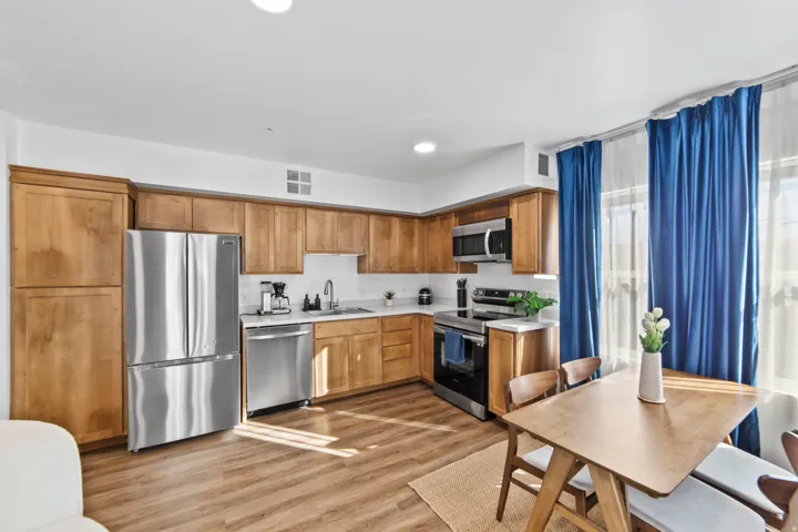 Kitchen featuring light countertops, stainless steel appliances, light wood-type flooring, recessed lighting, and wood finish cabinetry