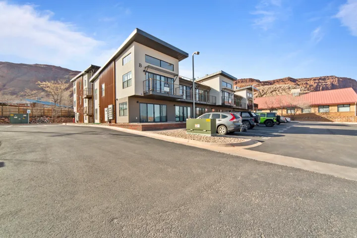 View of building exterior with a mountain view and uncovered parking