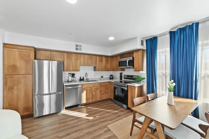 Kitchen featuring light countertops, stainless steel appliances, light wood-style floors, recessed lighting, and wood finish cabinets