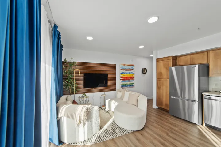 Living room with light wood-style flooring and recessed lighting
