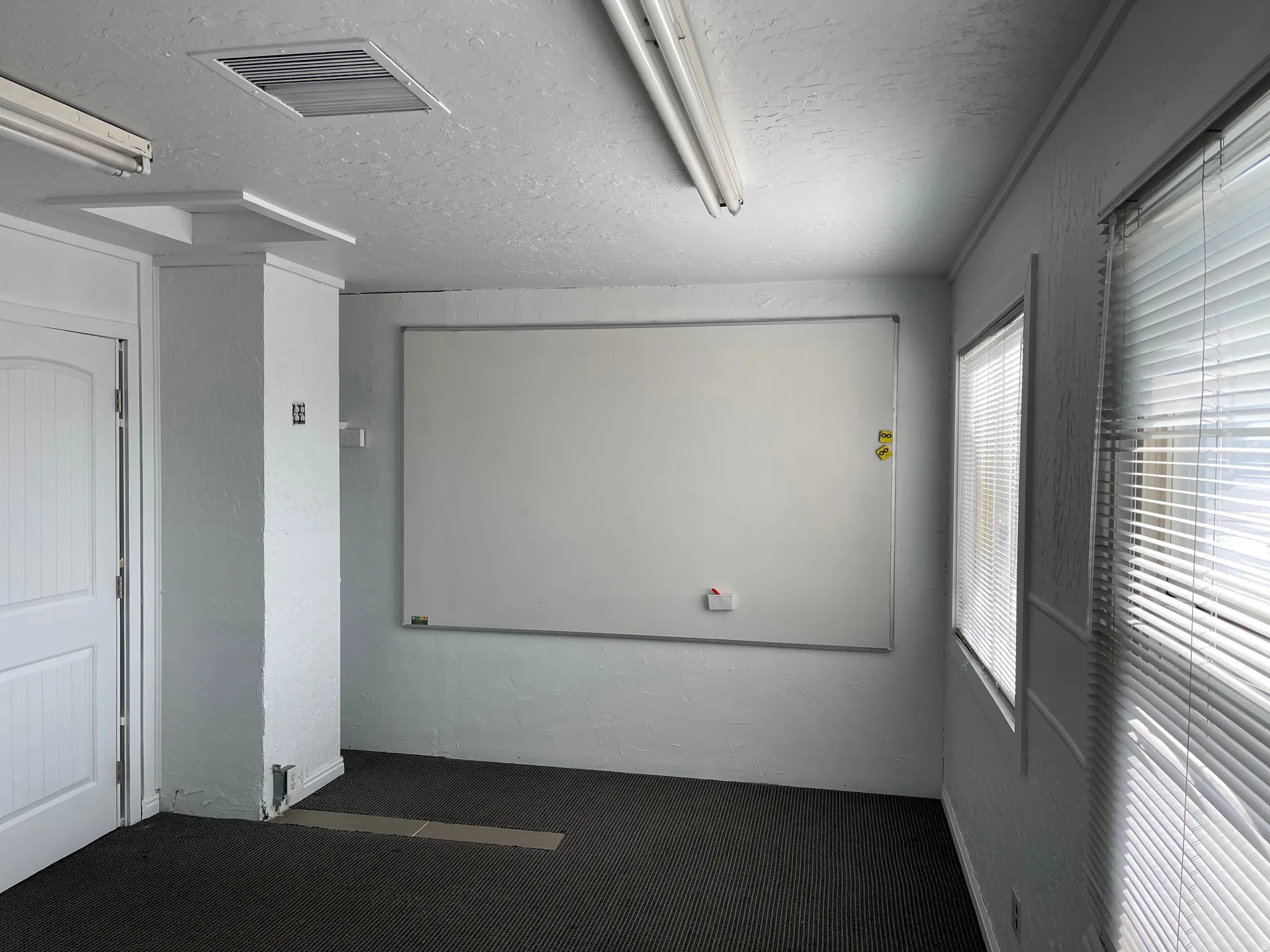 Spare room featuring a textured ceiling and dark colored carpet