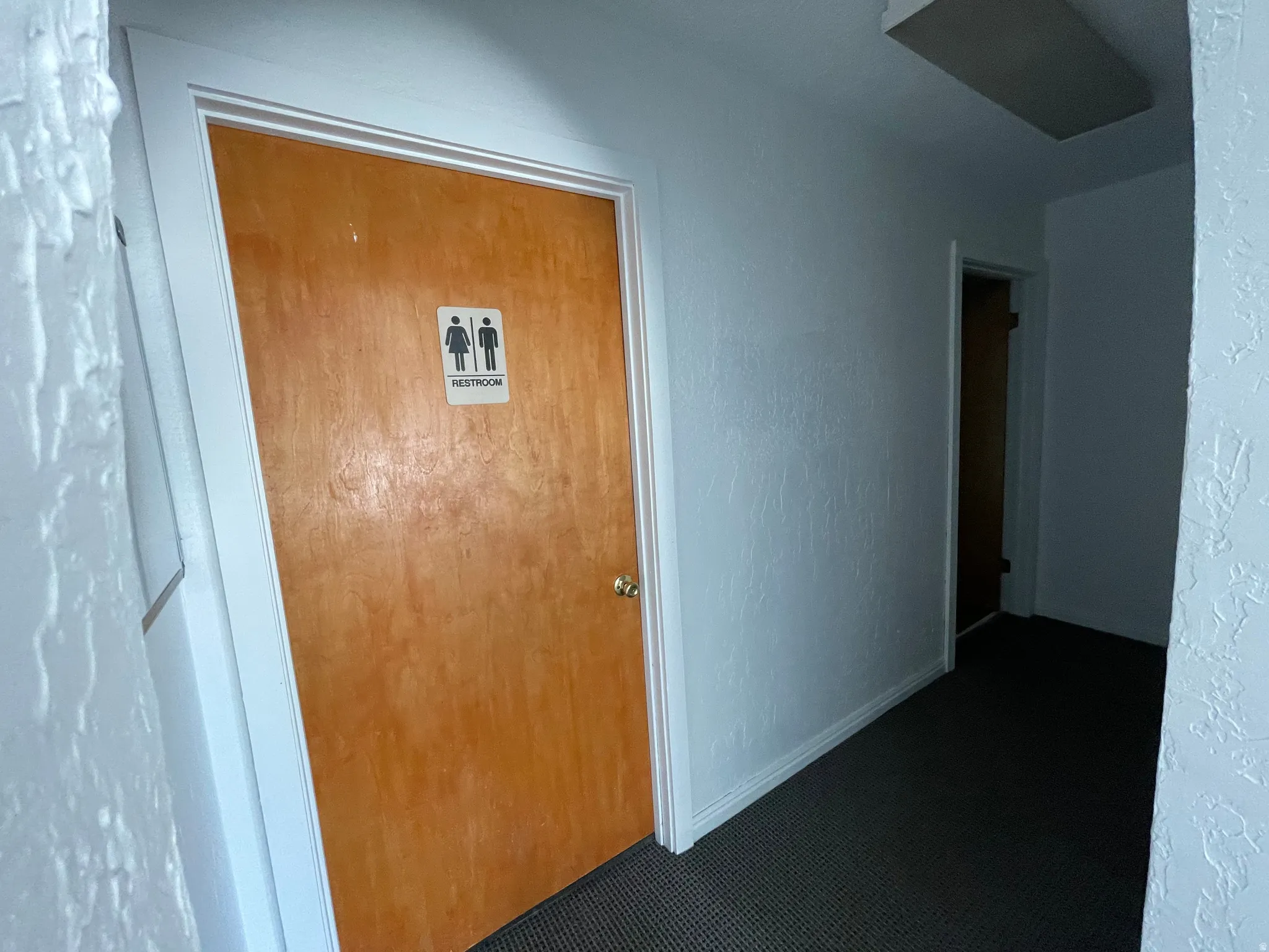 Corridor with a textured wall and carpet floors