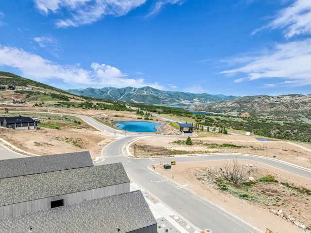 Expansive landscape featuring distant mountains, a natural water feature, paved roadways, and surrounding undeveloped terrain