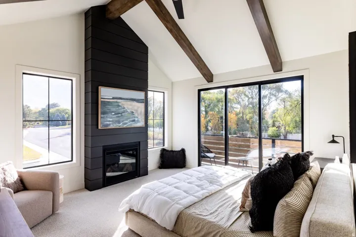 Bedroom with a large fireplace, carpet flooring, and access to outside
