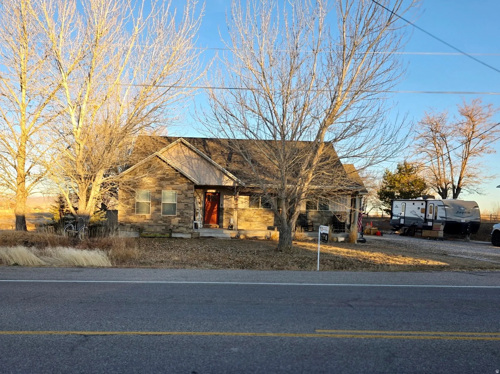 View of front of home featuring stone siding and a large porch