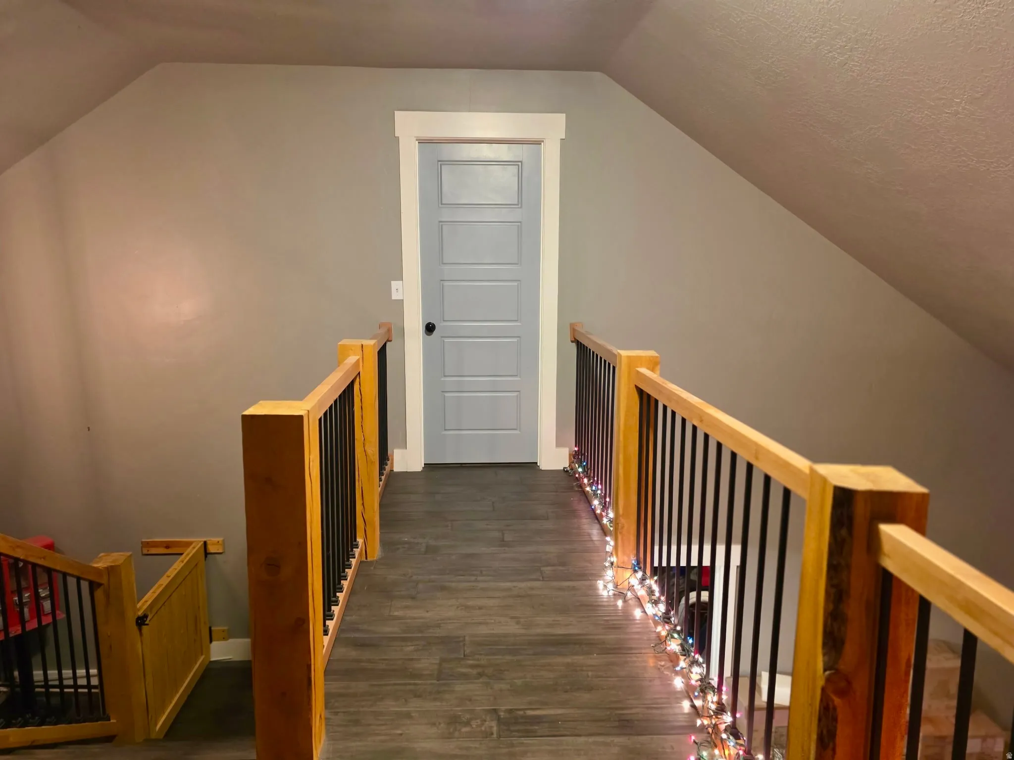 Stairway featuring wood finished floors, views into front and back of house from the catwalk