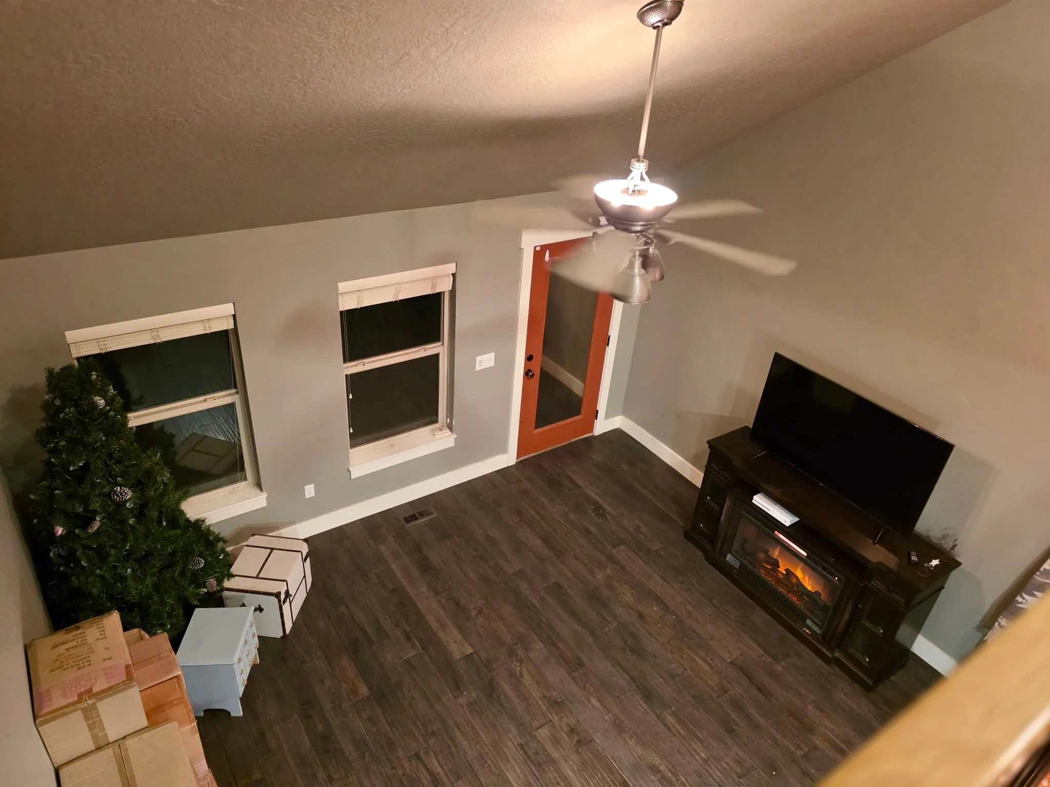 Unfurnished living room featuring ceiling fan, dark wood finished floors, a textured ceiling, and a glass covered fireplace
