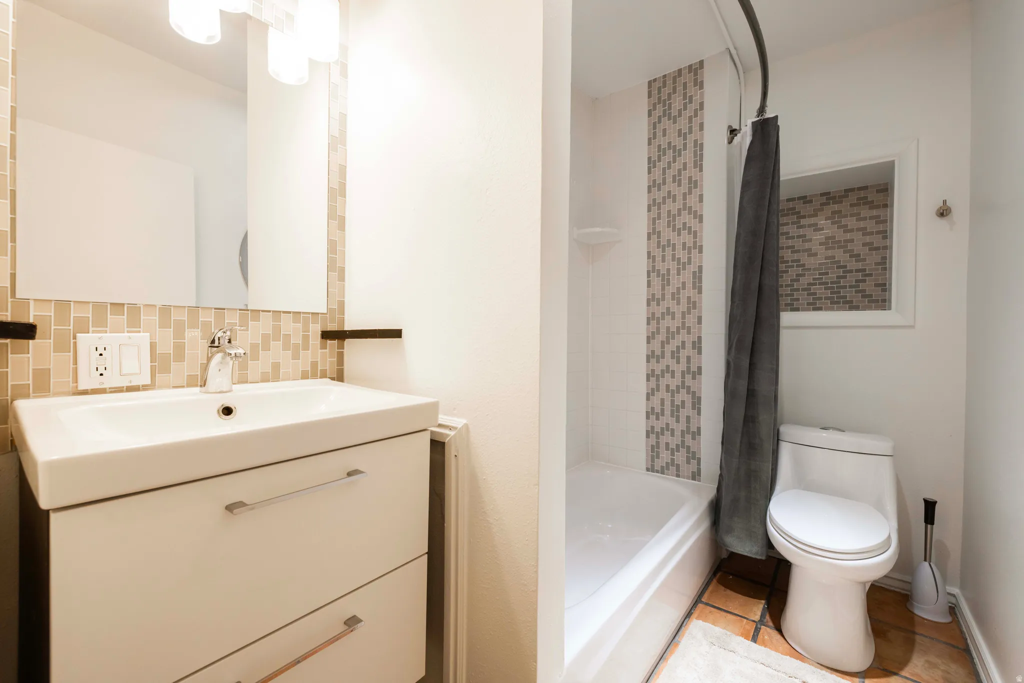 Apt. #3 Full bath with vanity, shower / tub combo, tile patterned flooring, and backsplash